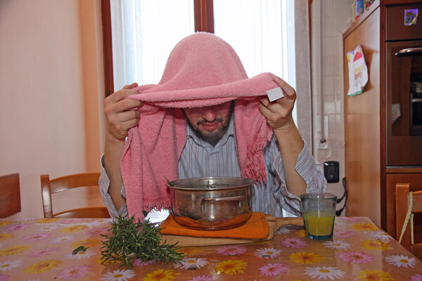 человек с розовым полотенцем дышать бальзамом пары для лечения простуды
