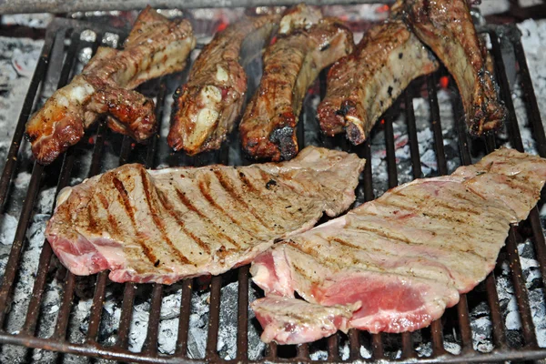 Bifes de vaca e costeletas cozinhadas de porco grelhado no churrasco — Fotografia de Stock