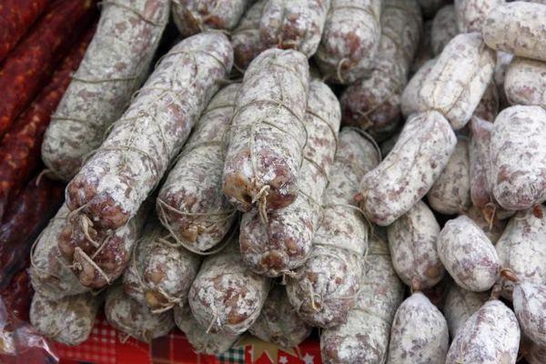 Grupo de salamis e salsichas picantes para venda no mercado local — Fotografia de Stock