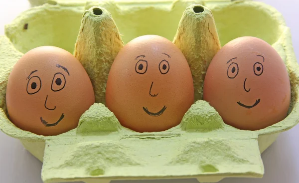 Tre uova sorridenti con occhi naso e bocca — Foto Stock