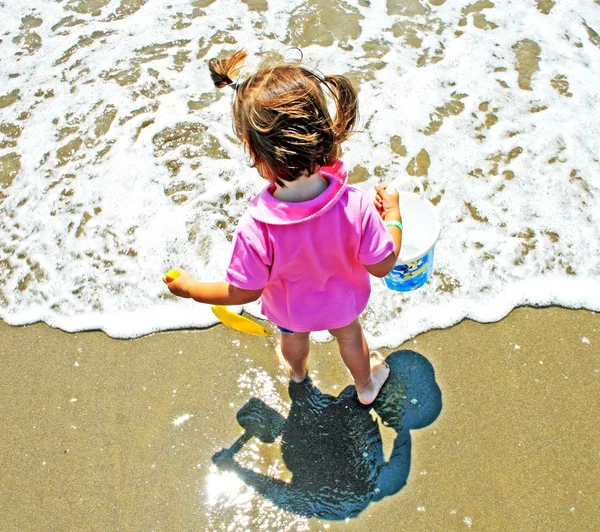 Ung flicka med en hink nära stranden i sommar — Stockfoto