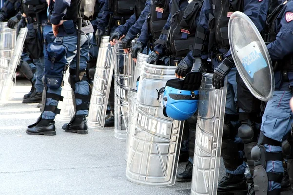 Policías en equipo antidisturbios con escudos y cascos y cascos duri — Foto de Stock