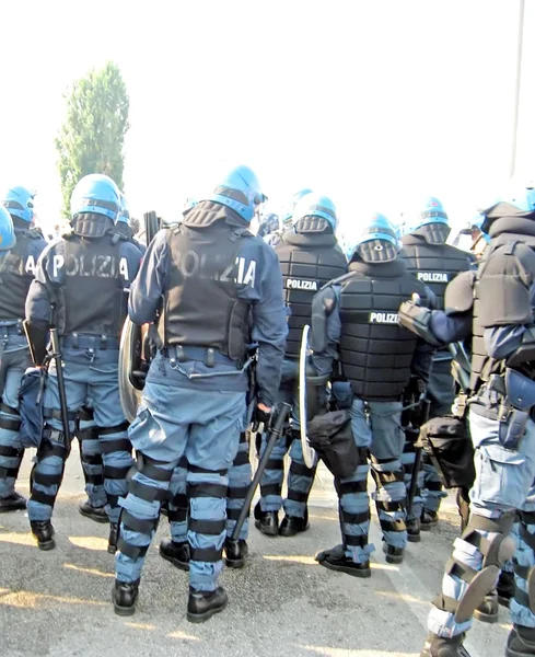 Policía en equipo antidisturbios con cascos y escudos el control del puente — Foto de Stock
