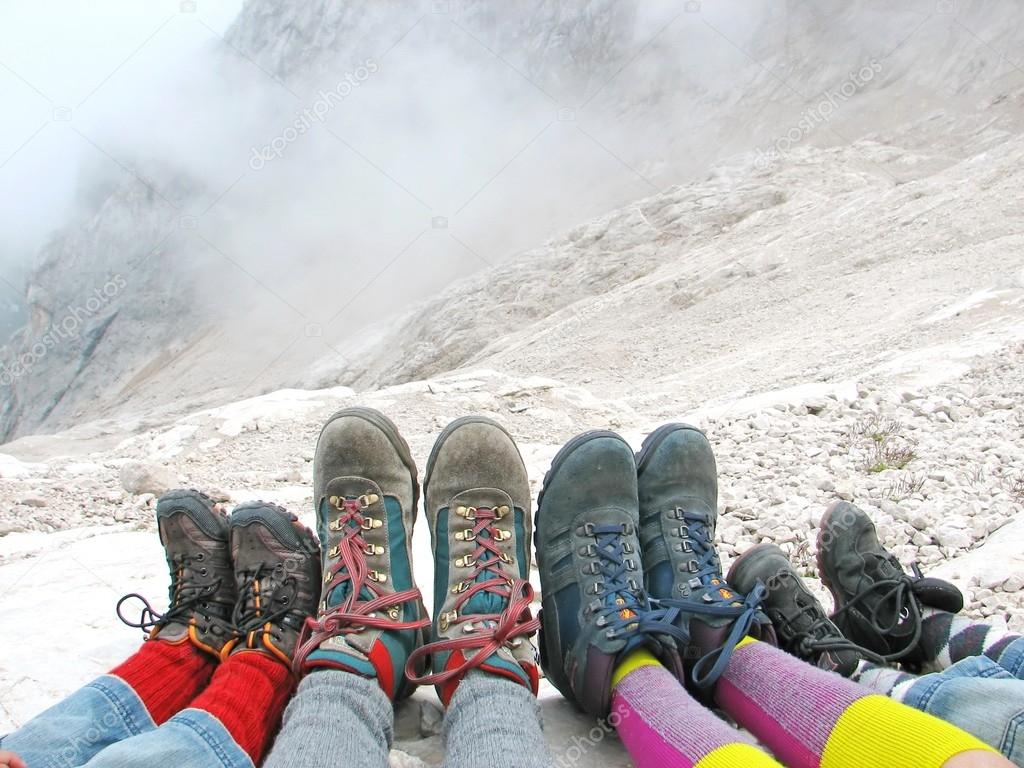 hiking boots of a family rest on the Dolomites