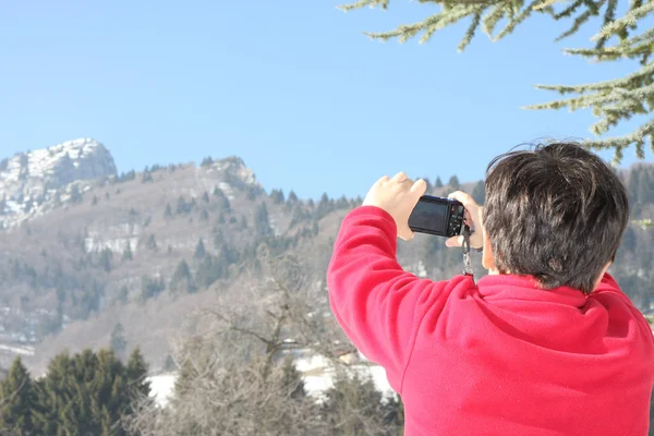 Ragazzo in maglione rosso che ha fotografato la vetta di una montagna — Foto Stock