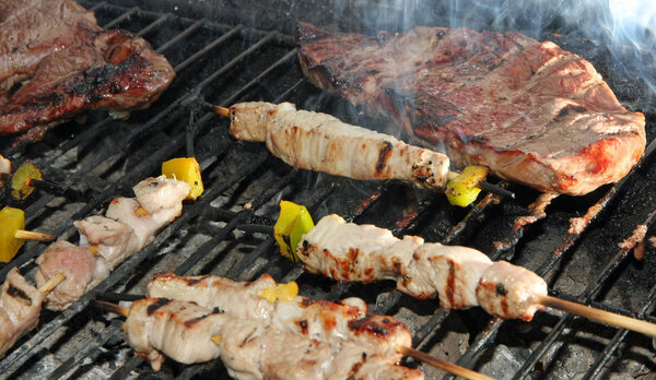 skewers of meat and beef fillet grilled on the barbecue in the g