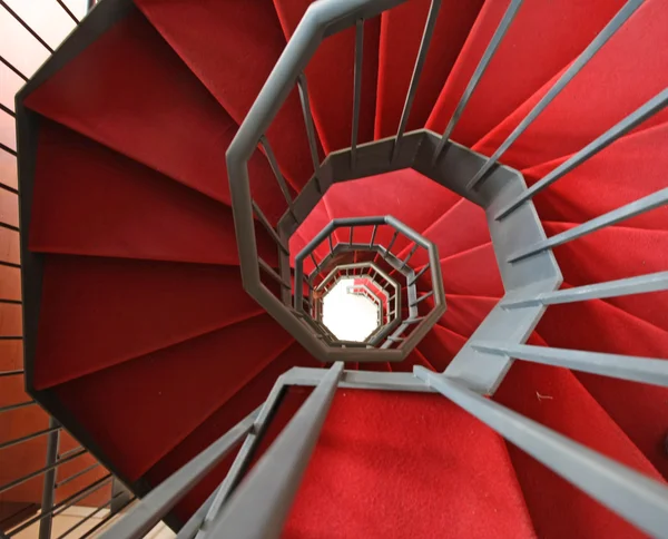 Eisen-Wendeltreppe mit elegantem roten Teppich und Spirale — Stockfoto