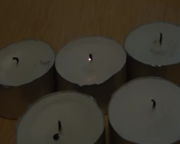 Pięć nieoświetlone świece, które świecą jakby za dotknięciem różdżki — Wideo stockowe