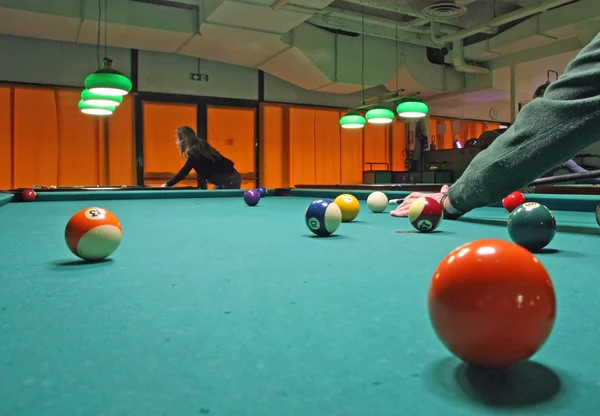 Salle de billard fumé avec des billes sur le tapis et des joueurs attentifs — Photo