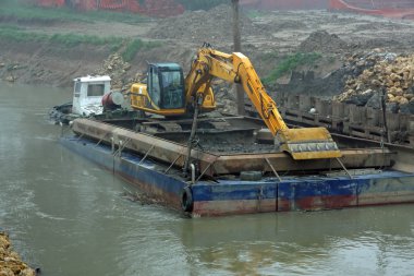 rive nehir yatağı temizlik için kazıyıcı bir mavna üzerinde