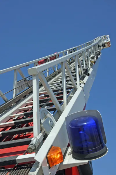中を押さえ込むに消防士の階段のライザーと青トラックのサイレン — ストック写真