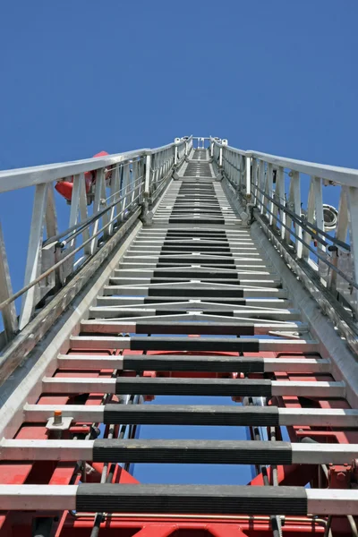 Pasos al cielo por un camión de bomberos con la autoscala en posiciones elevadas —  Fotos de Stock