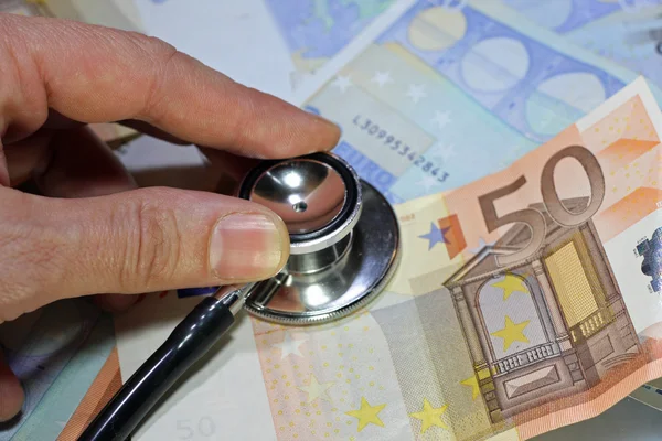 Stethoscope doctor leaned on many sick euro currency banknotes — Stock Photo, Image
