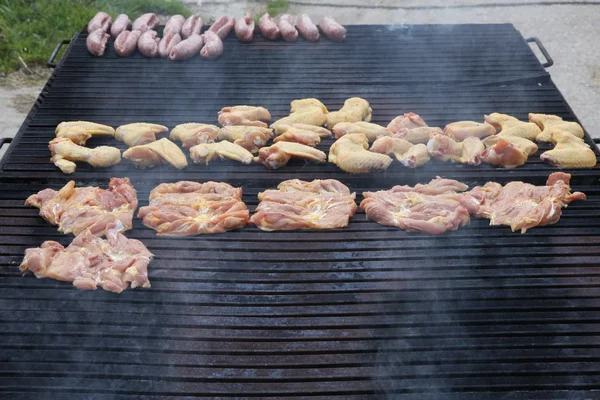 Величезний барбекю в саду зі смачним м'ясом до вогню — стокове фото