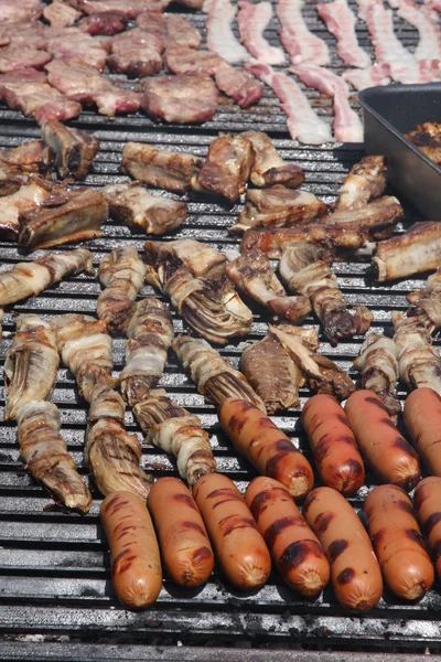 Grote openlucht barbecue grill met varkensworst en baken — Stockfoto