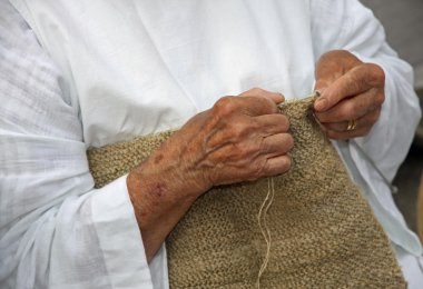 Yün süveter işlerken yaşlı bir kadının elleri