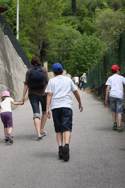 Família que corre ao longo de uma estrada estreita subida destrói — Fotografia de Stock