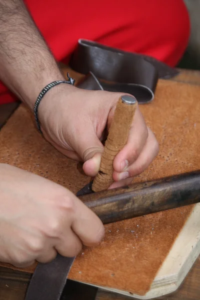 Artesano experto que trabaja el cuero con el awl y el martillo — Foto de Stock