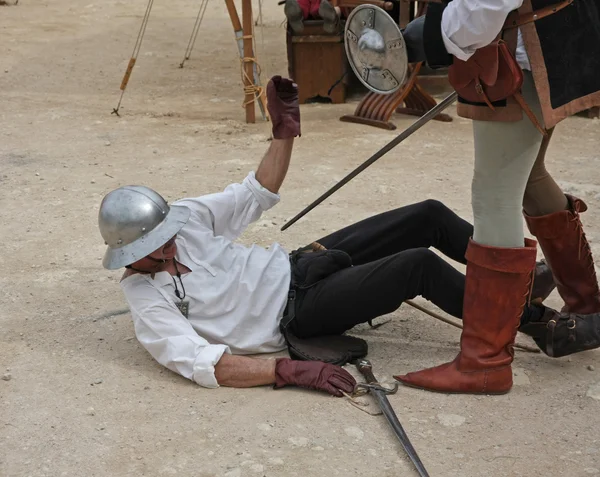 Antike mittelalterliche Tracht mit einem Soldaten, der tödlich verwundet wird, während er sim — Stockfoto