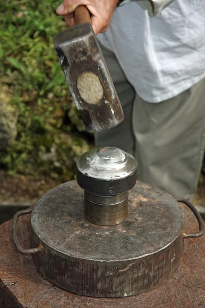 Heavy iron Poker beats against the anvil to form a mold of a coi — Stock Photo, Image