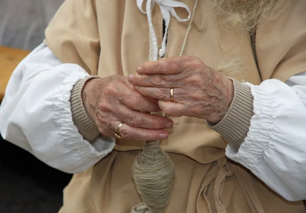 Mains d'une femme âgée pendant le traitement du pull en laine — Photo