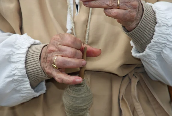 Manos de una anciana durante el procesamiento de suéter de lana — Foto de Stock