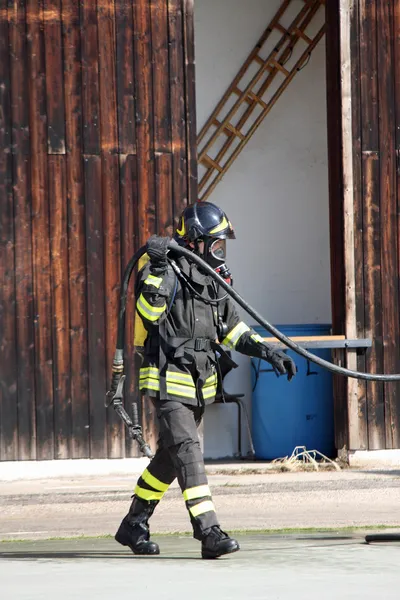 Bombeiros corajosos com fogo tanque de oxigênio durante um exercício realizado — Fotografia de Stock