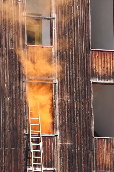 Feuer in einem Haus mit dickem, orangefarbenem Rauch, der aus dem — Stockfoto