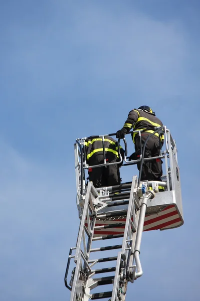 Bombeiros na cesta da escala do caminhão de bombeiros quando s — Fotografia de Stock