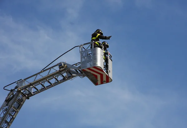 Bombeiros na cesta da escala do caminhão de bombeiros quando s — Fotografia de Stock