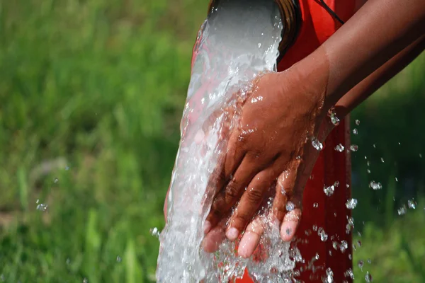 Umyjte si ruce pod silným proudem vody z požární hydrant — Stock fotografie