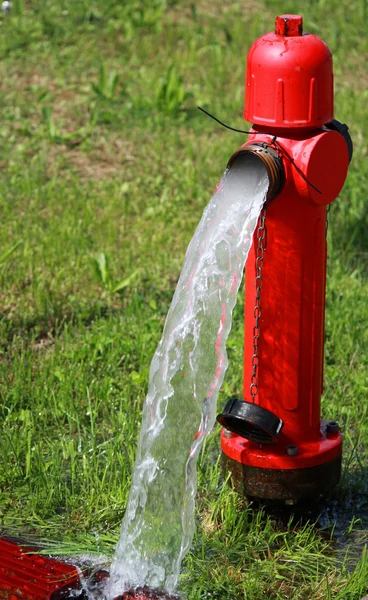 Poderoso fluxo de água saindo com ímpeto de um hidrante de rua — Fotografia de Stock