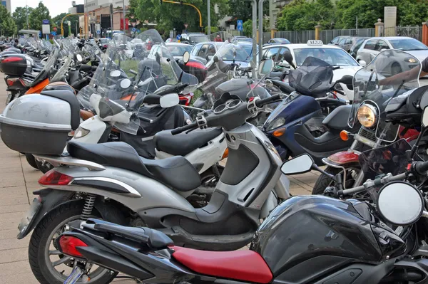 Muchos scooters y motocicletas estacionados en el aparcamiento de la carretera — Foto de Stock