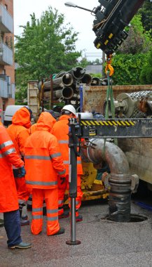 işçi yağmurluk takım zor bir pompa yol yüklemeye çalışır.