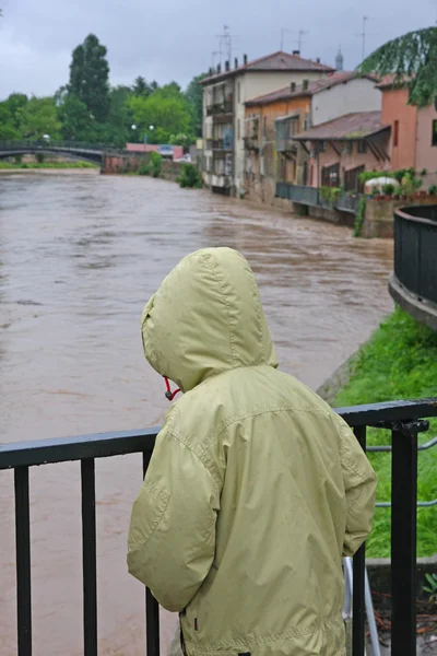 Bambino con orologio impermeabile con costernazione il fiume in crescita — Foto Stock