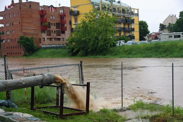 Působivé výfuku se vlévá do řeky dešťové vody a bahna — Stock fotografie