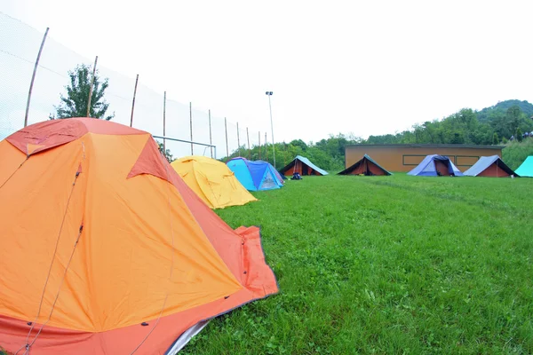 Tábor s táborníky skautské stany na zelené louce — Stock fotografie