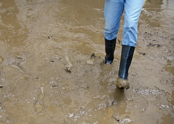 Bottes noires dans la boue du déluge après une catastrophe naturelle — Photo