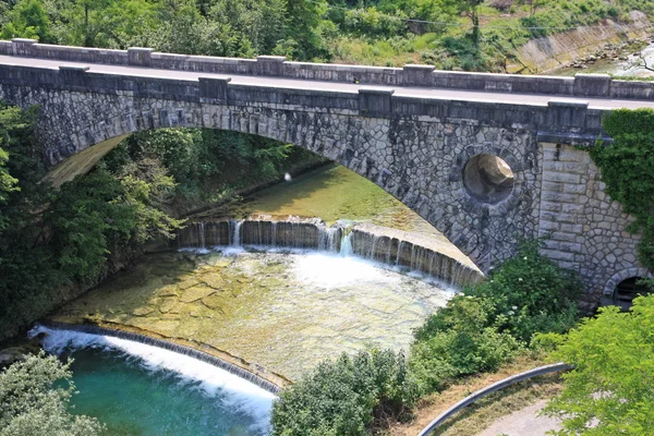 Ponte de pedra velha sobre o riacho nas montanhas com — Fotografia de Stock