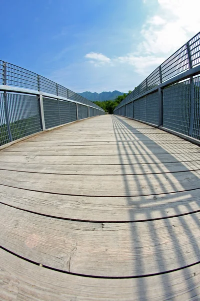 Long bridge with a wooden walkway and handrail made of galvanize — Stock Photo, Image
