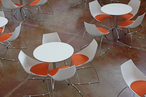 Salle d'attente avec tables et chaises orange et blanches — Photo