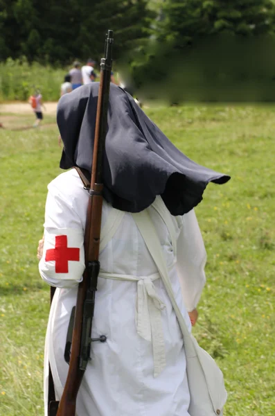 Red Cross nurse nun with a big gun on her shoulders — Stock Photo, Image