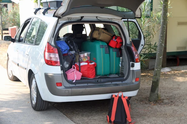 Två gröna resväskor och många väskor i bilen — Stockfoto