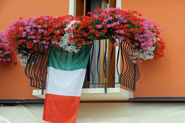 Balcón floreciente con Geranios y la bandera de Italia —  Fotos de Stock