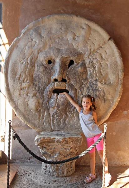 Nice young girl puts her hand inside the Bocca della Verita, Rome — Stock Photo, Image