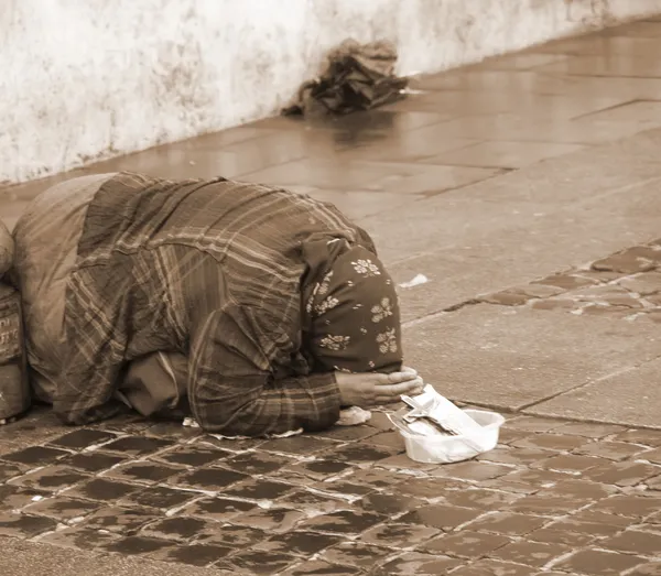 Цыганка в грязной одежде во время попрошайничества на улице — стоковое фото