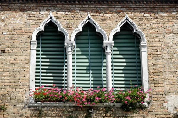 Luxuriöser, blumiger Balkon im venezianischen Stil mit Bogenfenstern — Stockfoto