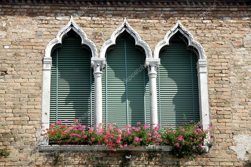 Venetian Style luxurious flowery balcony in venetian style with arched windows Venetian Style luxurious flowery balcony in venetian style with arched windows