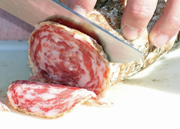 Butcher cut the salami with a sharp knife 2 — Stock Photo, Image
