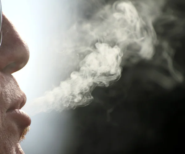 Backlit sigarettenrook en chain-smoker — Stockfoto